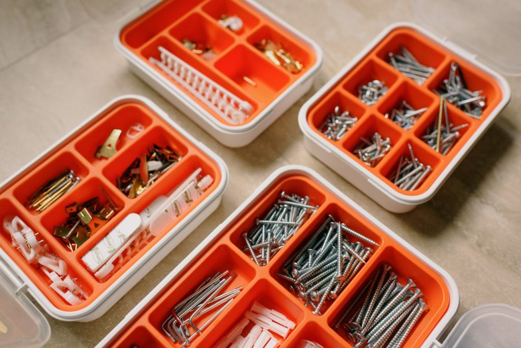 From above of boxes with different metal nails and plastic dowels in workshop